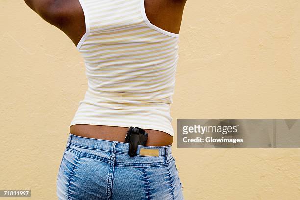 close-up of a mobile phone in a woman's back pocket - phone in back pocket stock pictures, royalty-free photos & images