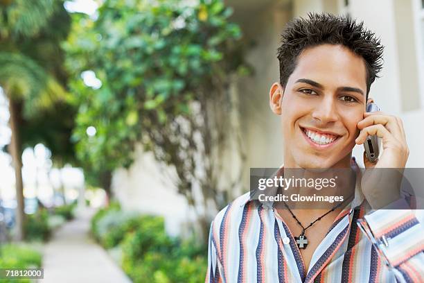 portrait of a young man talking on a mobile phone - cross stripes shirt stockfoto's en -beelden