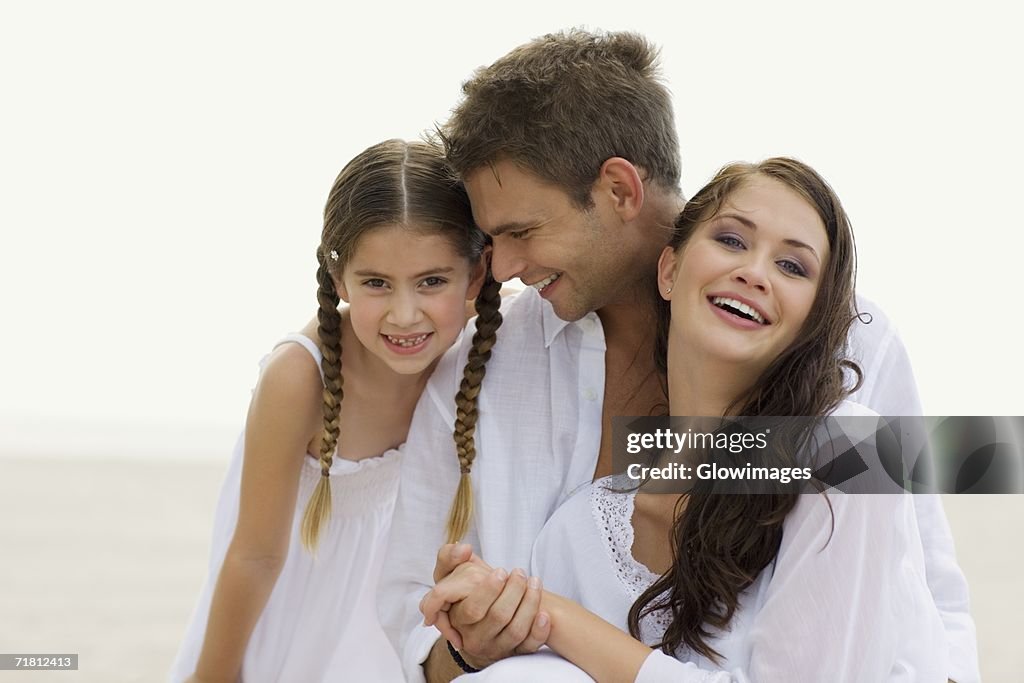 Close-up of a young couple and their daughter on the beach