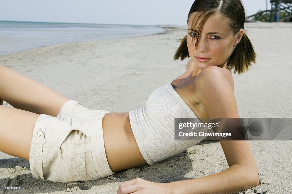 Portrait of a young woman reclining on the beach