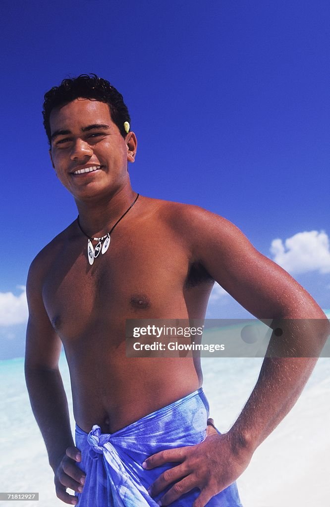 Portrait of a young man standing with arms akimbo, Hawaii, USA