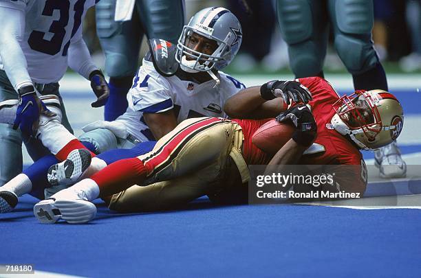 Terrell Owens the San Francisco 49ers lands in the end-zone for a touchdown with Ryan McNeil of the Dallas Cowboys during the game at the Texas...