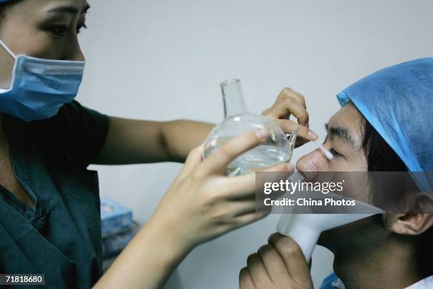 Doctor prepares to anaesthetize a patient before a laser eye surgery, which utilizes computer-controlled excimer laser to correct myopia, at an...