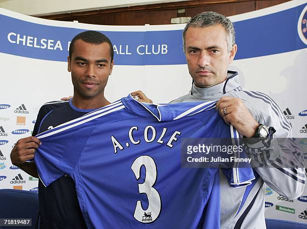 New Chelsea signing Ashley Cole and manager Jose Mourinho pose for photos before a press conference at the Chelsea training ground on September 8,...