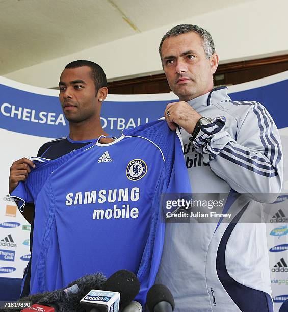 New Chelsea signing Ashley Cole and manager Jose Mourinho pose for photos before a press conference at the Chelsea training ground on September 8,...