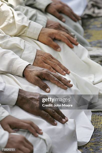 Afghan refugees kneel during prayers on September 8, 2006 at the Khazana camp on the outskirts of Peshawar, Pakistan. While some of the refugees have...