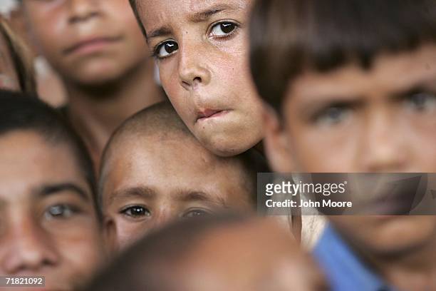 Afghan refugees gather on September 8, 2006 at the Khazana refugee camp on the outskirts of Peshawar, Pakistan. While some of the refugees have...
