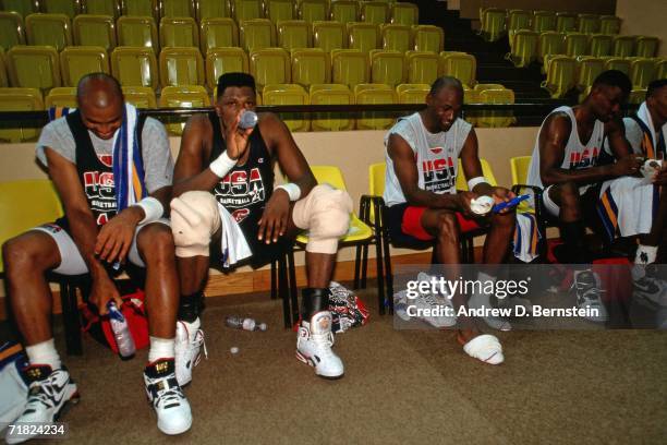 Charles Barkley, Patrick Ewing, Michael Jordan and David Robinson of the United States National Team take a rest on the sideline during practice in...