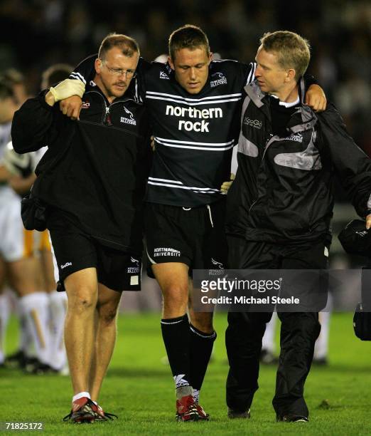 Jonny Wilkinson of Newcastle is helped off the field after damaging his right knee during the Guinness Premiership match between Newcastle Falcons...