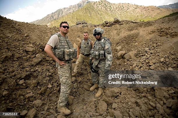 Two US Army soldiers from an Explosives Ordnance Disposal Team along with a US Navy Lieutenant, right, pose for a picture while checking the results...