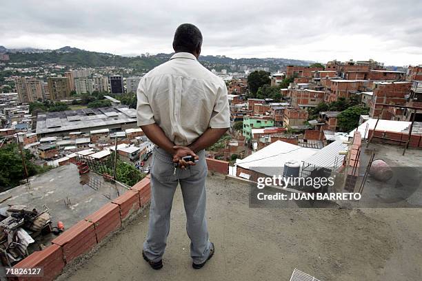 Un hombre observa desde lo alto de una construccion el barrio mas peligroso de Caracas, Petare, apodado "Saigon", el 7 de setiembre de 2006. Cada fin...