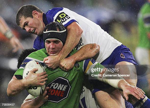 Troy Thompson of the Raiders is tackled by Andrew Ryan of the Bulldogs during the NRL Third Qualifying Final between the Bulldogs and the Canberra...