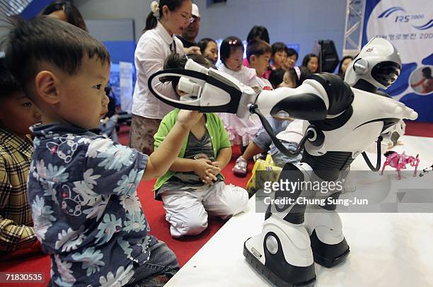 Children play with robots at the "2006 Robot Show" at the Kintex centre on September 9, 2006 in Goyang, South Korea. Robonova-I can sit down, stand...
