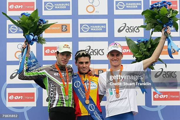 Winner Javier Gomez of Spain celebrates with third placed Sven Riederer of Switzerland and second placed Brad Kahlefeldt of Australia after the Mens...