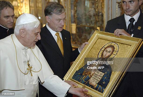 Pope Benedict XVI looks at a picture he was given by German President Horst Koehler 09 September 2006 at the Residenz in Munich. Pope Benedict XVI...