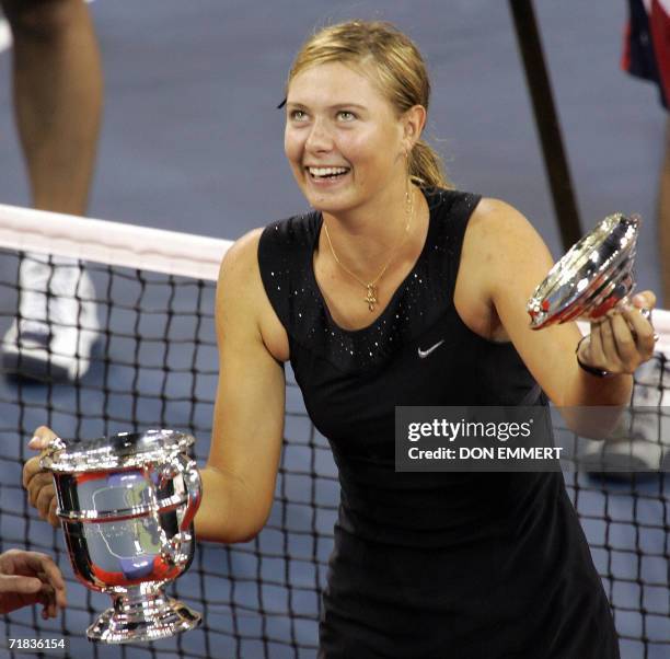 Number three seeded Maria Sharapova of Russia holds up the US Open trophy after her win over number two seeded Justine Henin-Hardenne of Belgium in...