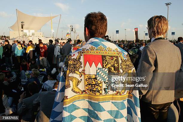 Pilgrims wearing traditional Bavarian folk clothing and a Bavarian flag await the arrival of Pope Benedict XVI for an open-air mass September 10,...