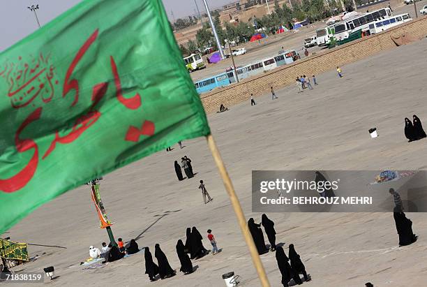 Iranians walk in the courtyard of the Jamkaran mosque as a religious Shiite banner reading "O Mahdi" flies in the mosque outside the religious city...