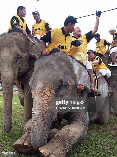 Polo players from Scotland celebrate while sitting on their elephants after beating Germany in penalties during the final of the sixth King's Cup...