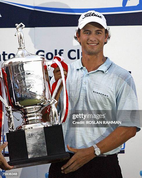 Adam Scott of Australia smiles as he holds the trophy after winning the final round of the Singapore Open golf tournament, 10 September 2006. Scott...