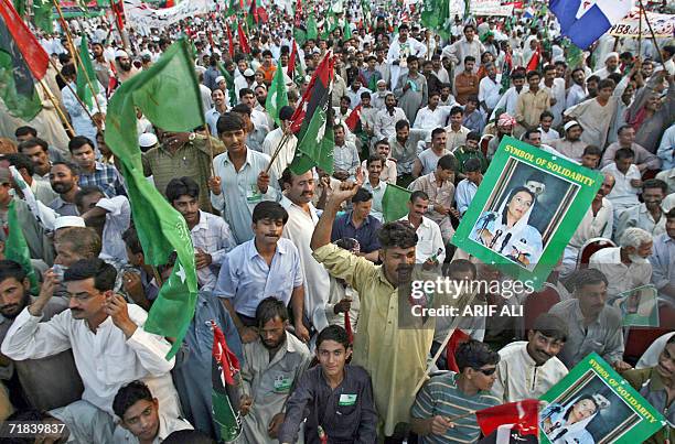 Activists of the Alliance for Restoration of Democracy hold party flags as they shout anti-government slogans during a rally in Lahore, 10 September...