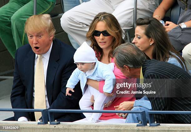 Donald Trump, baby son Barron and wife Melania Trump watch the men's final between Roger Federer of Switzerland and Andy Roddick during the U.S. Open...