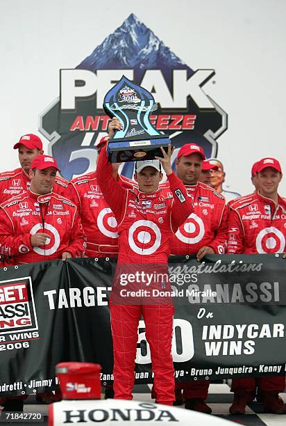 Dan Wheldon, driver of the Target Chip Ganassi Dallara Honda, holds the winners trophy in victory lane after winning the IRL IndyCar Series PEAK...