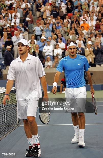 Andy Roddick and Roger Federer of Switzerland walk back to the sidelines after Federer defeated Roddick in the men's final of the U.S. Open at the...