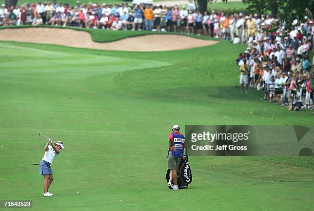 Annika Sorenstam of Sweden hits her second shot from the eighth fairway as her caddie Terry McNamara looks on during the final round of the John Q....