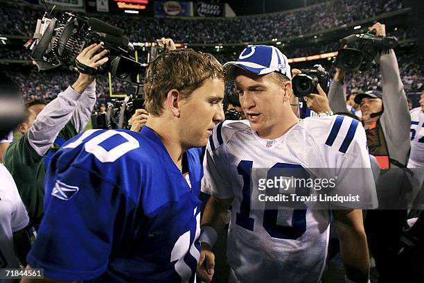 Quarterback Eli Manning of the New York Giants congratulates his brother quarterback Peyton Manning of the Indianapolis Colts on his 26-21 victory on...