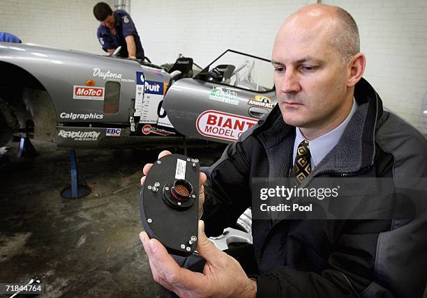 Major crash investigation section officer Senior Constable Alun Mills inspects the 'black box' recorder which was recovered from Peter Brock's...