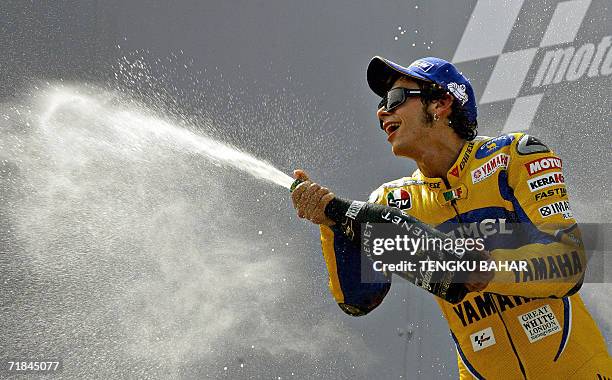 Malaysian MotoGP winner Valentino Rossi celebrates by spraying champagne on the winner's podium at the Sepang International Racing Circuit, 10...