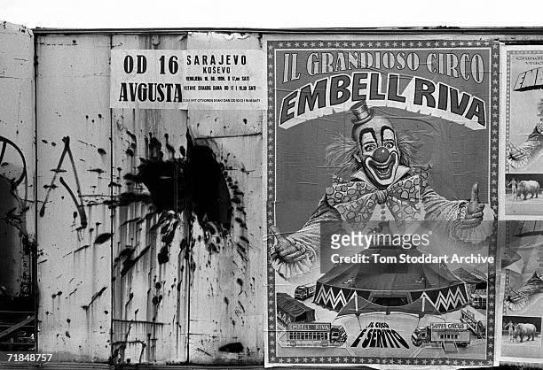 Signs Of The Times - A poster advertising a circus carries the smiling face of a clown on a shell damaged wall during the siege of Sarajevo.