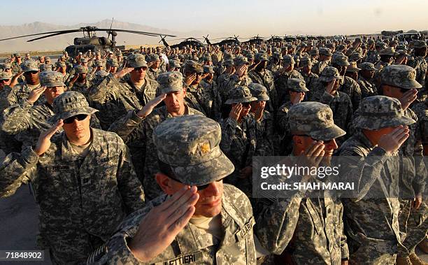 Soldiers salute during a ceremony at Bagram air base, 50 kms north of Kabul, 11 September 2006 in remembrance of the victims of the 11 September 2001...