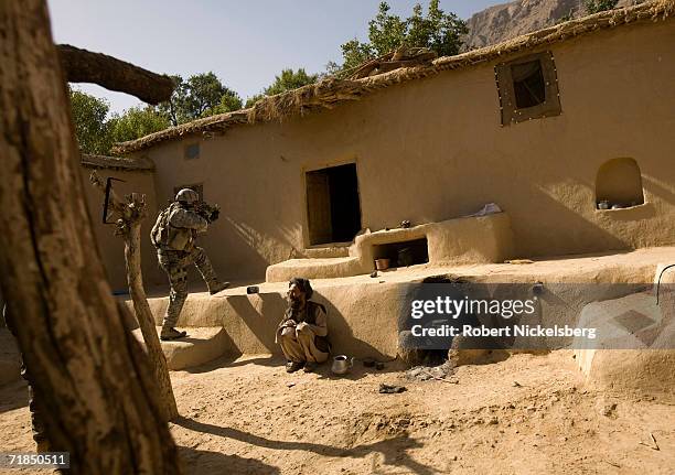 Army soldiers from Charlie Company, 1-4 Infantry Regiment and US Special Forces enter a village elder's house in Takatu village as they search for...