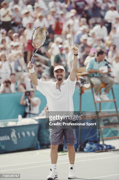 American tennis player Andre Agassi raises his arms in celebration after beating Sergi Bruguera of Spain to win the gold medal for the United States...