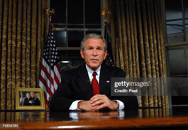 President George W. Bush sits at his desk in the Oval Office of the White House after addressing the nation on the anniversary of the 2001 terrorist...