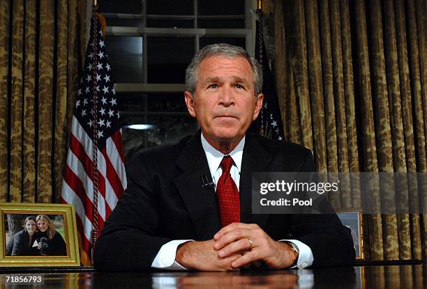 President George W. Bush sits at his desk in the Oval Office of the White House after addressing the nation on the anniversary of the 2001 terrorist...