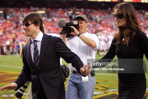 Tom Cruise and Katie Holmes walk off the field before a game between the Minnesota Vikings and the Washington Redskins during the first Monday Night...