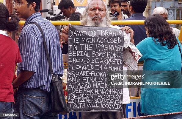 An Indian man holds a banner demanding justice outside the Terrorist And Disruptive Activities Act court during the first day of verdicts in the 1993...