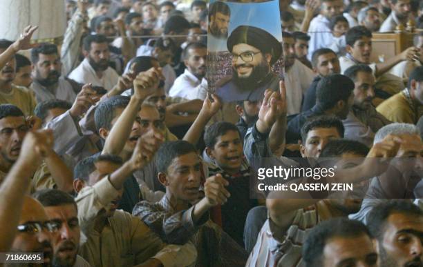 Supporters of radical Shiite cleric Moqtada al-Sadr hold a poster of Lebanese Hezbollah leader Sheikh Hassan Nasrallah as they rally in a protest...