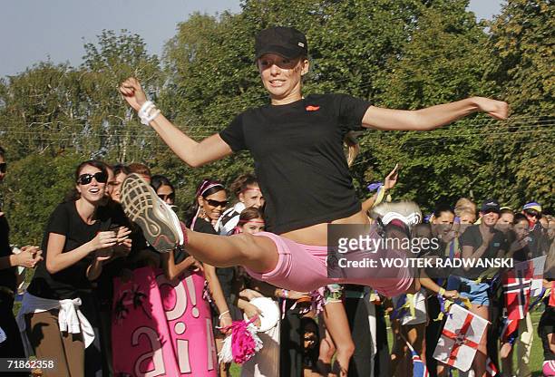 Miss Italy Elizaveta Migatcheva jumps doing the air splits during Miss Sport competition as other Miss World contestants cheer her in the background...