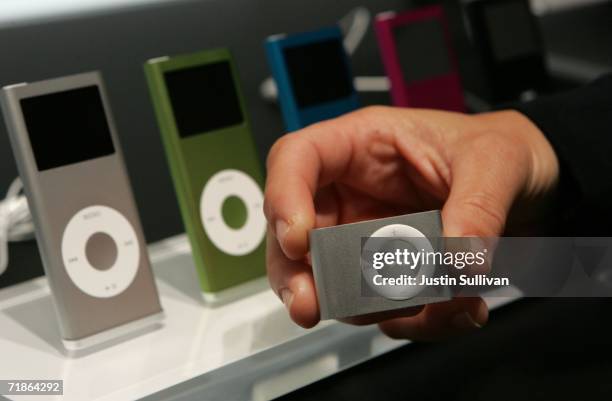 Woman holds a new iPod Shuffle in front of a display of new iPod Nanos at an Apple media event September 12, 2006 in San Francisco, California. Apple...