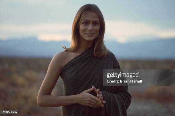 Portrait of American model and actress Lauren Hutton as she poses in a sari with her hands together, mid 1970s.