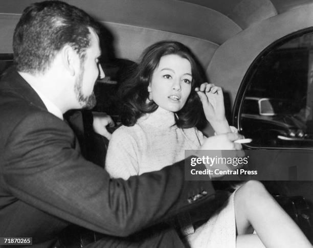 Christine Keeler leaves her flat in Devonshire Street, London, with her racing driver friend, Paul Mann for Marylebone Court, where she is expected...