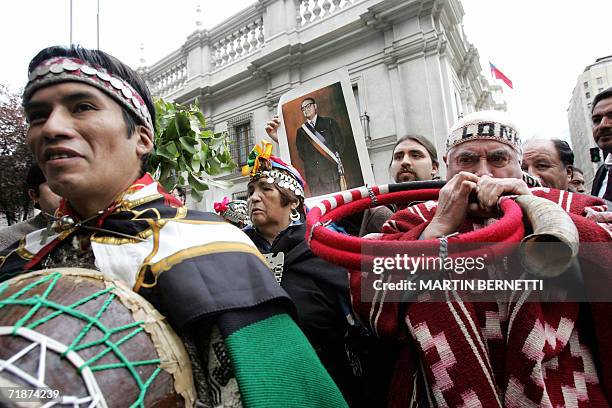 Indigenas Mapuches, uno de ellos con un retrato del ex presidente Salvador Allende, realizan una "limpia" al palacio La Moneda en Santiago, el 13 de...