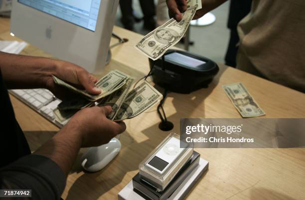 Consumer pays cash for a new iPod nano at the Apple Store on Fifth Avenue on September 13, 2006 in New York. The update on the popular music player...