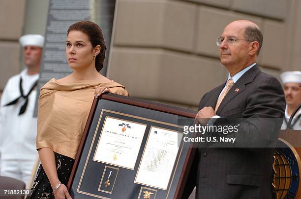 In this handout provided by the U.S. Navy, Secretary of the Navy, Dr. Donald C. Winter presents the Navy Cross to Maria Paz Leveque, the wife of...