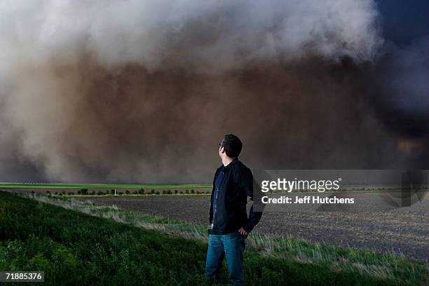 Tour guest Hugh Costello, from London, England, watches a storm bear down on him during a Tempest Tours storm chasing tour across the Great Plains...