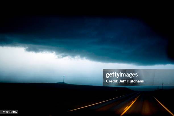 Power lines along a Nebraska country road illuminated by a Tempest Tours storm chase van's headlights are seen through a dust storm of a powerful...